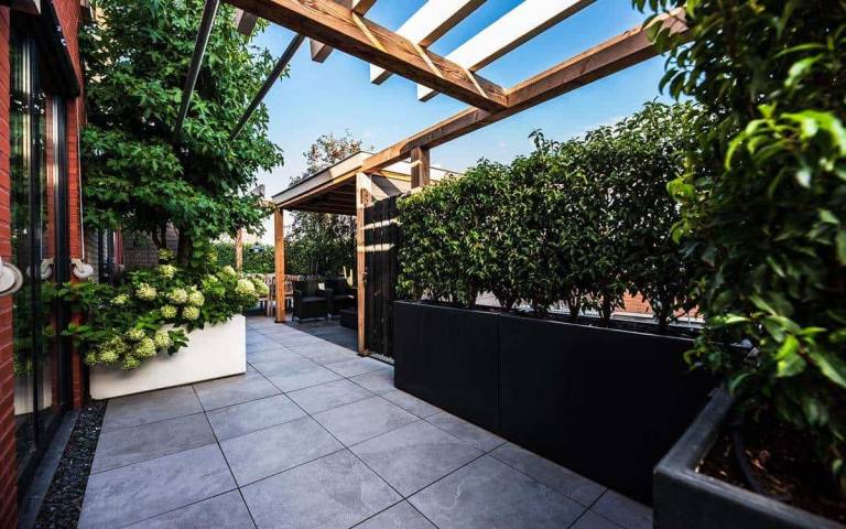 Dakterras met houten pergola en hoge groene plantenbakken
