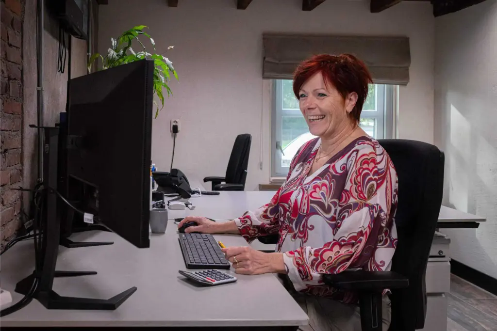 Vrouw werkt aan een bureau met beeldschermen