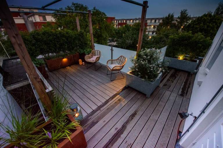 Houten dakterras met pergola in de avond