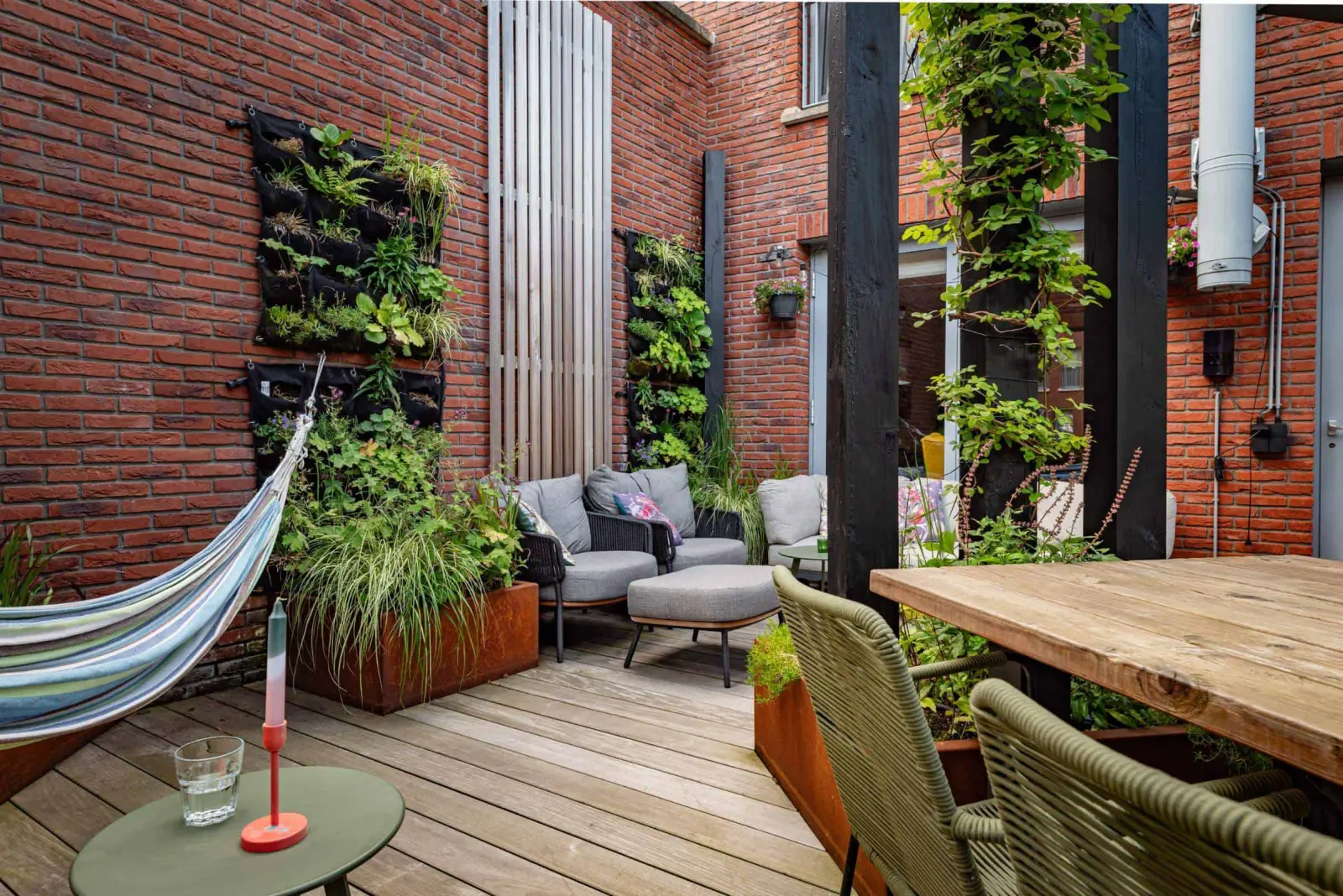 Houten terras met hangmat, zitplek en verticale beplanting