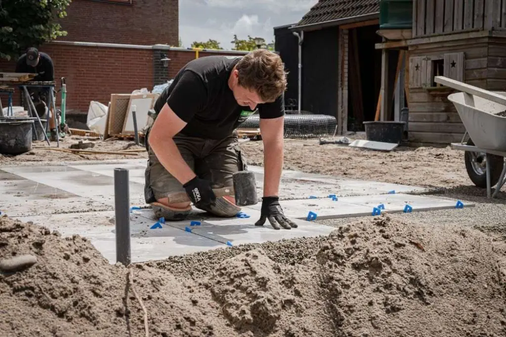 Hovenier legt bestrating op een voorbereid zandbed