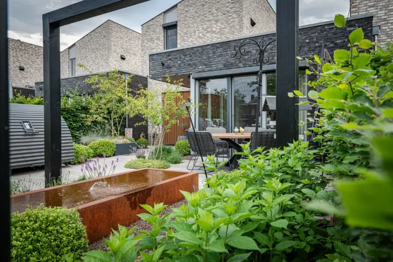 Tuinpad langs waterbak en groene borders