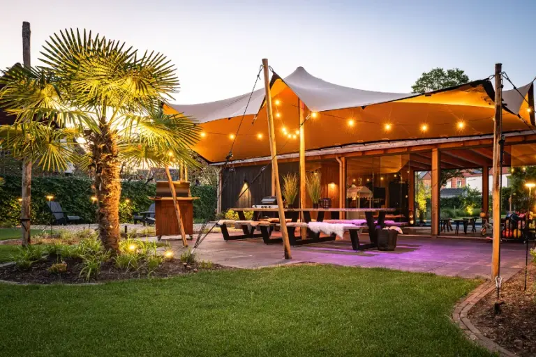 Gazon voor verlichte overkapping en palmboom